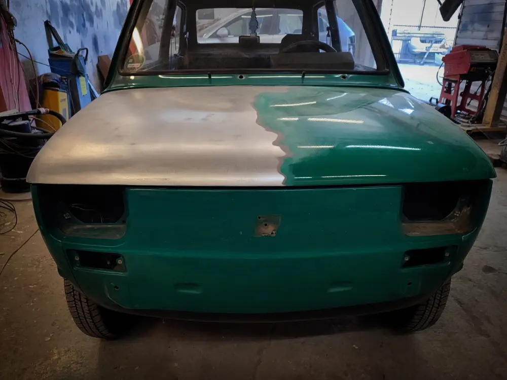 Fiat 126p przed renowacją — zielony lakier, karoseria w trakcie naprawy